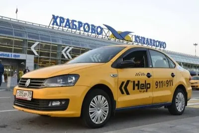Желтое такси стоит и ожидает заказчика у аэропорта Храброво.