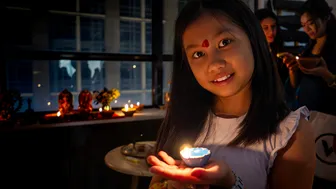 Girl celebrating Diwali with a lit diya lamp, festival of lights.